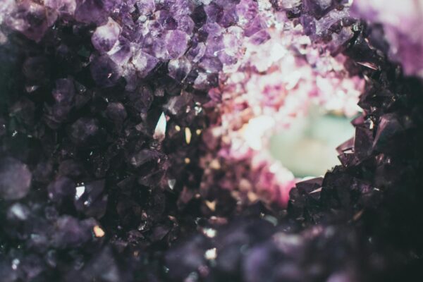 Macro photo of a rough amethyst geode with a tunnel view, showcasing vibrant purple crystals.