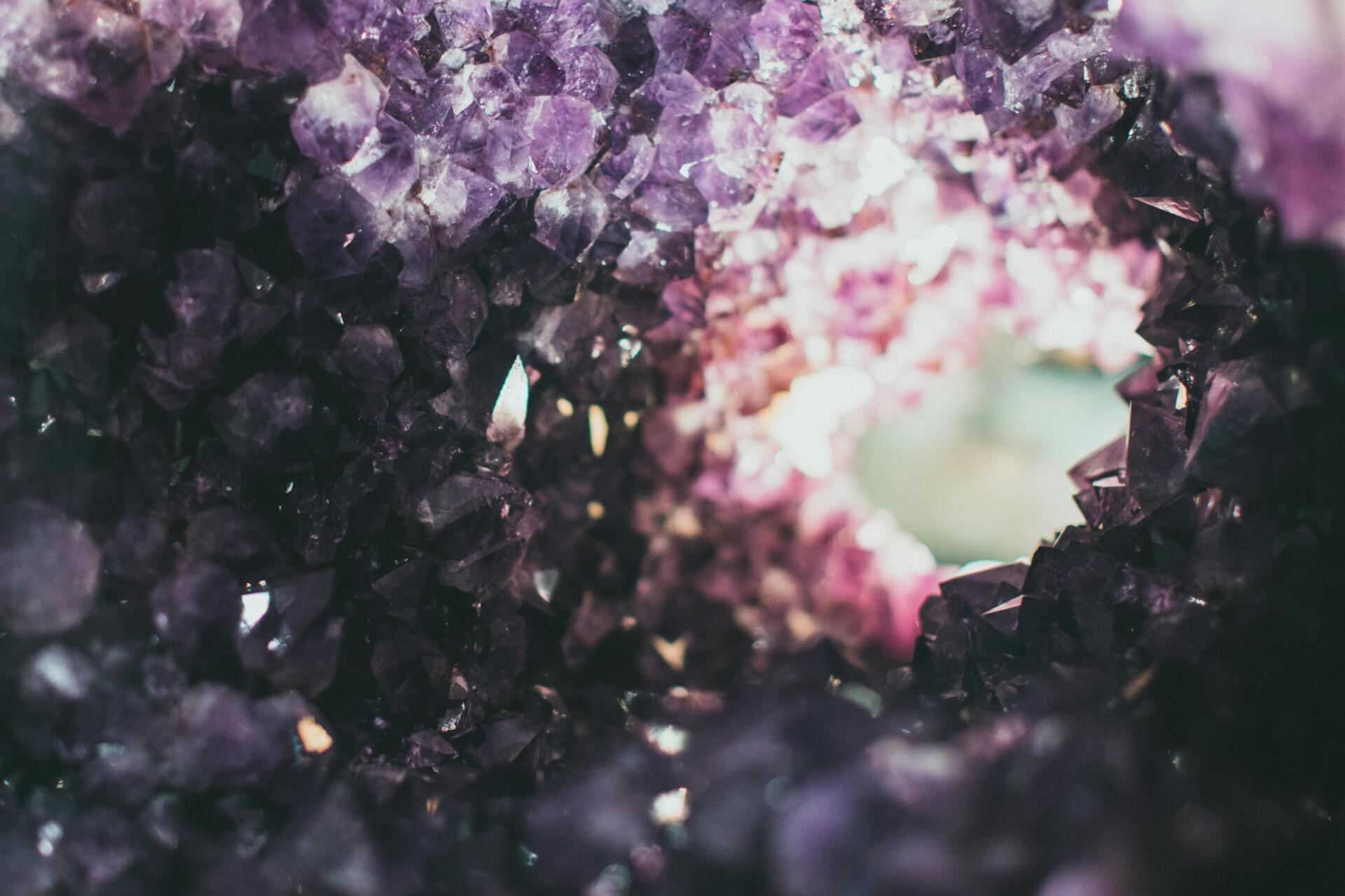 Macro photo of a rough amethyst geode with a tunnel view, showcasing vibrant purple crystals.